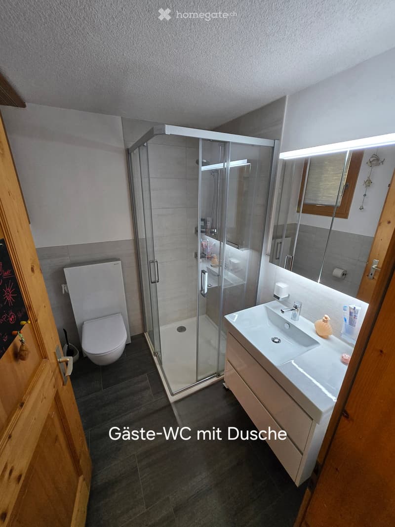 Bathroom. Modern bathroom with a glass-enclosed shower, toilet, sink with cabinet, and mirror above the sink. The floor is tiled, and the walls are painted in neutral tones.