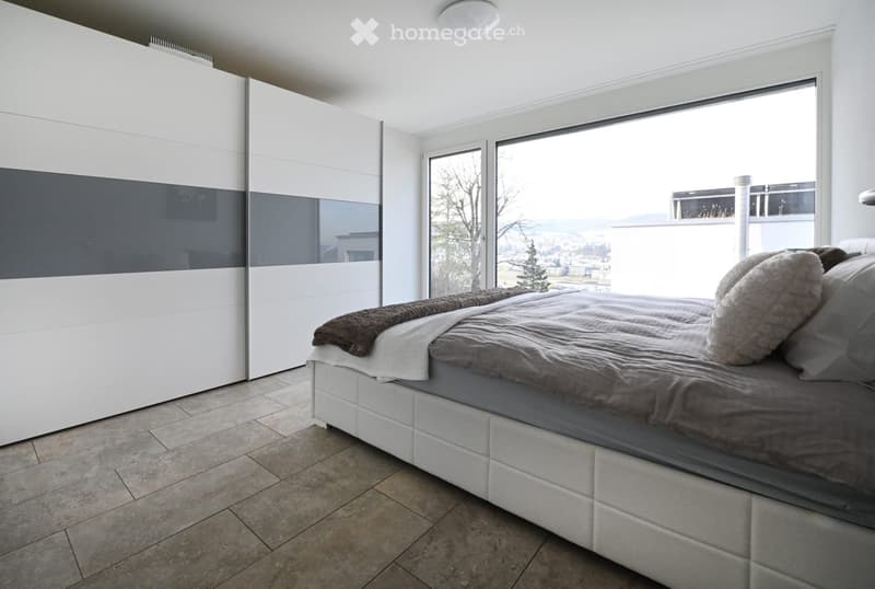 Bedroom. Modern bedroom with a large bed, white wardrobe, and large windows offering a scenic view.