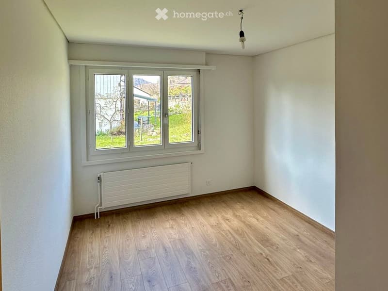 empty room, white walls, wooden floor, white radiator, window with view