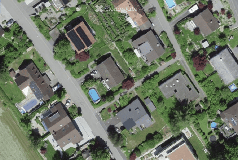 Residential area with multiple houses, each with a garden and a swimming pool