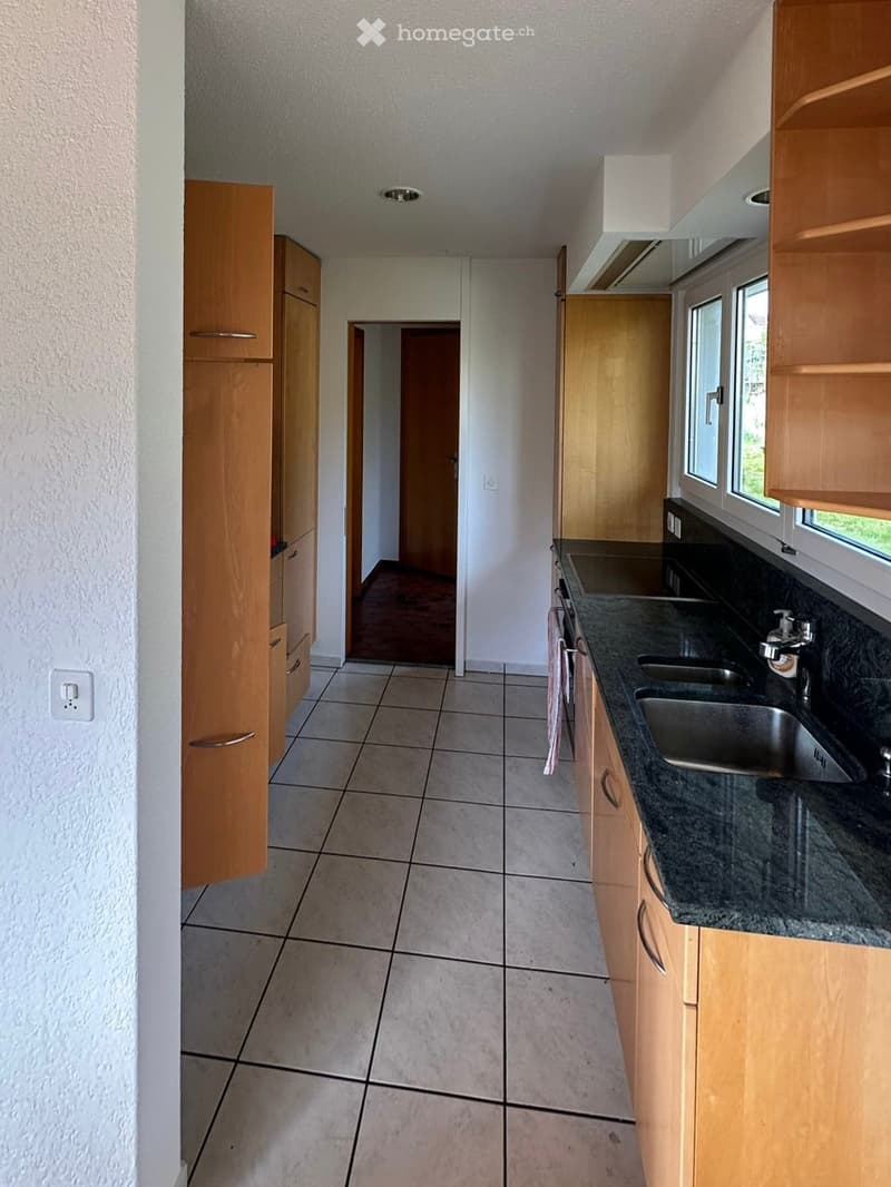 kitchen with wooden cabinets, granite countertops, stainless steel sink, tiled floor, window