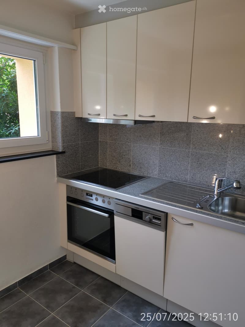 compact kitchen with a stove, oven, sink, and built-in cabinets, floor tile, window