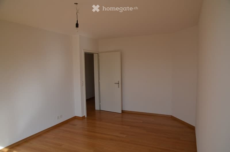 empty room, white walls, wooden floor, white door, power outlets