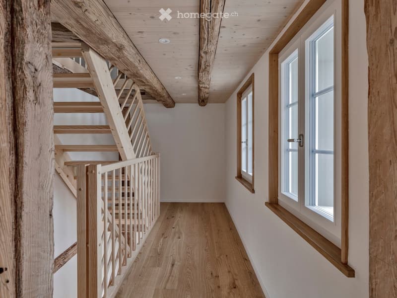 wooden staircase, wooden floor, white walls, two windows, wooden ceiling beams