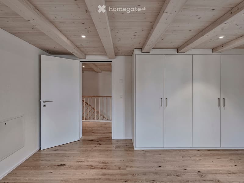 empty room, wooden ceiling, wooden floor, white walls, closet, open door leading to stairs