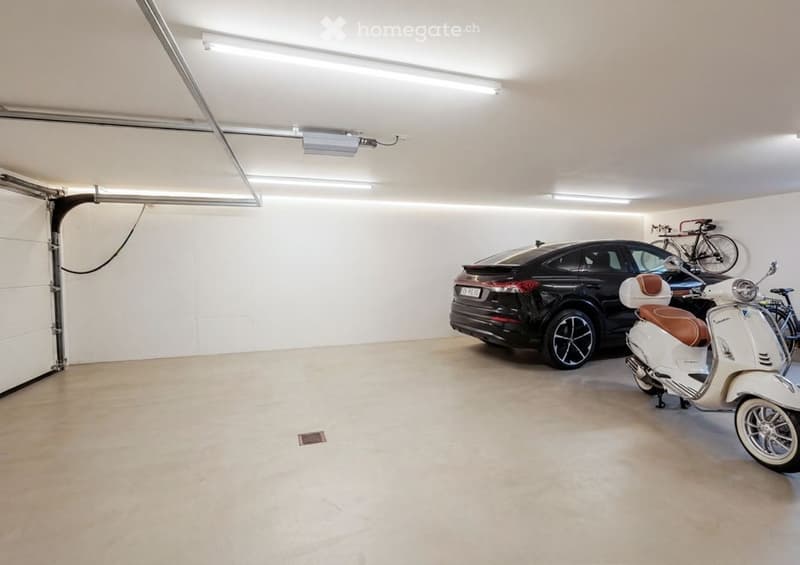 {"visible_features": ["Garage"], "type": "Garage", "objects": [], "description": "Clean, well-lit underground garage with a black car, a white scooter, and a bicycle on a rack.", "localized_descriptions": {"EN": "Clean, well-lit underground garage with a