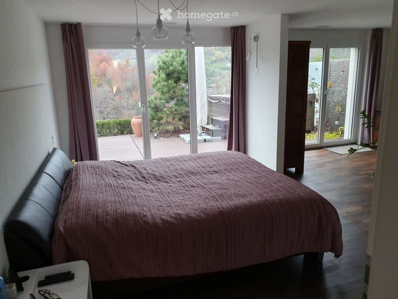 large bed, large windows leading to balcony, wooden floor, sliding glass doors