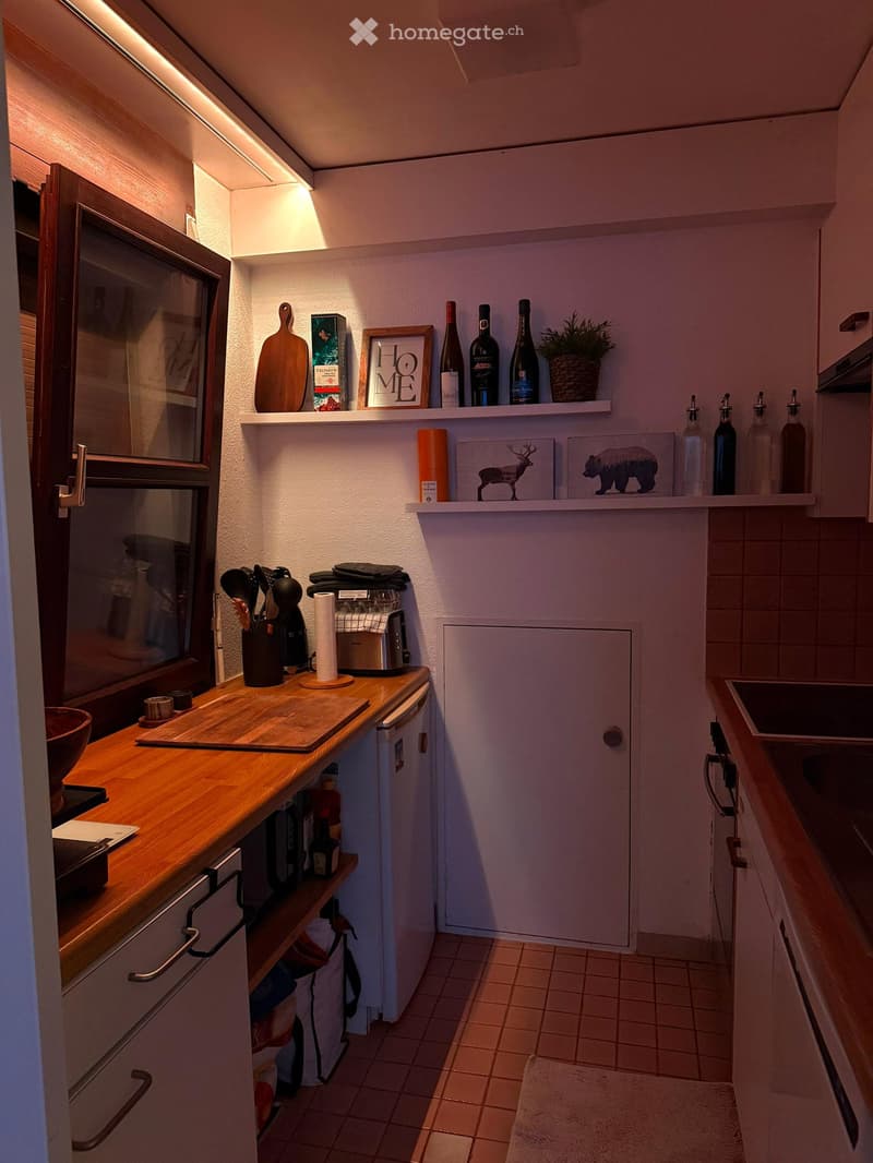 {"type": "Kitchen", "objects": ["cutting board", "fridge", "toaster", "sink", "cupboard", "bottle", "framed picture", "bowl", "cup", "faucet", "shelf", "plant", "bottle", "framed picture", "framed picture", "bottle", "bottle", "bottle", "bottle", "bottle"