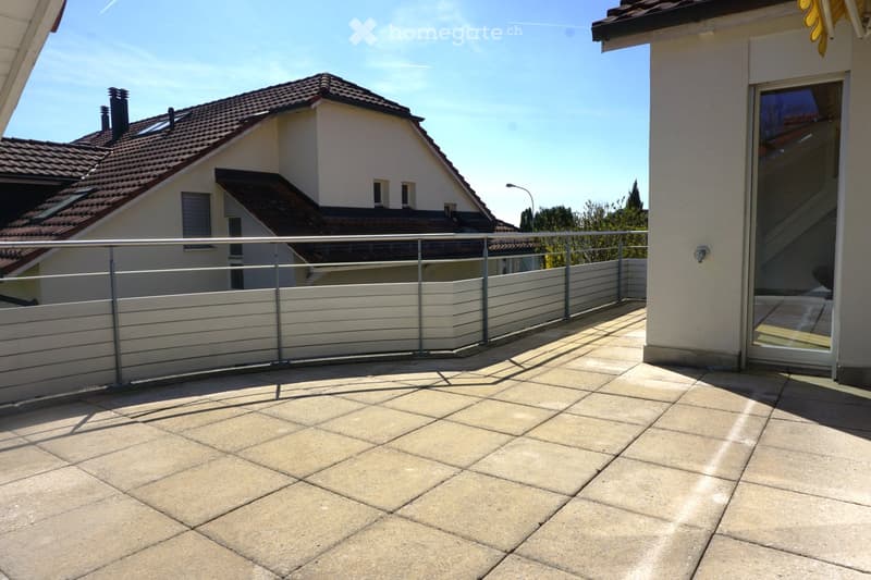 Balcony with tiled floor, metal railing, and a view of neighboring houses.