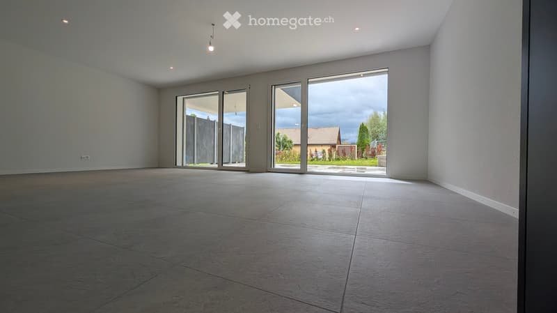 Empty room with large sliding glass doors leading to an outdoor area, tiled floor, and white walls.