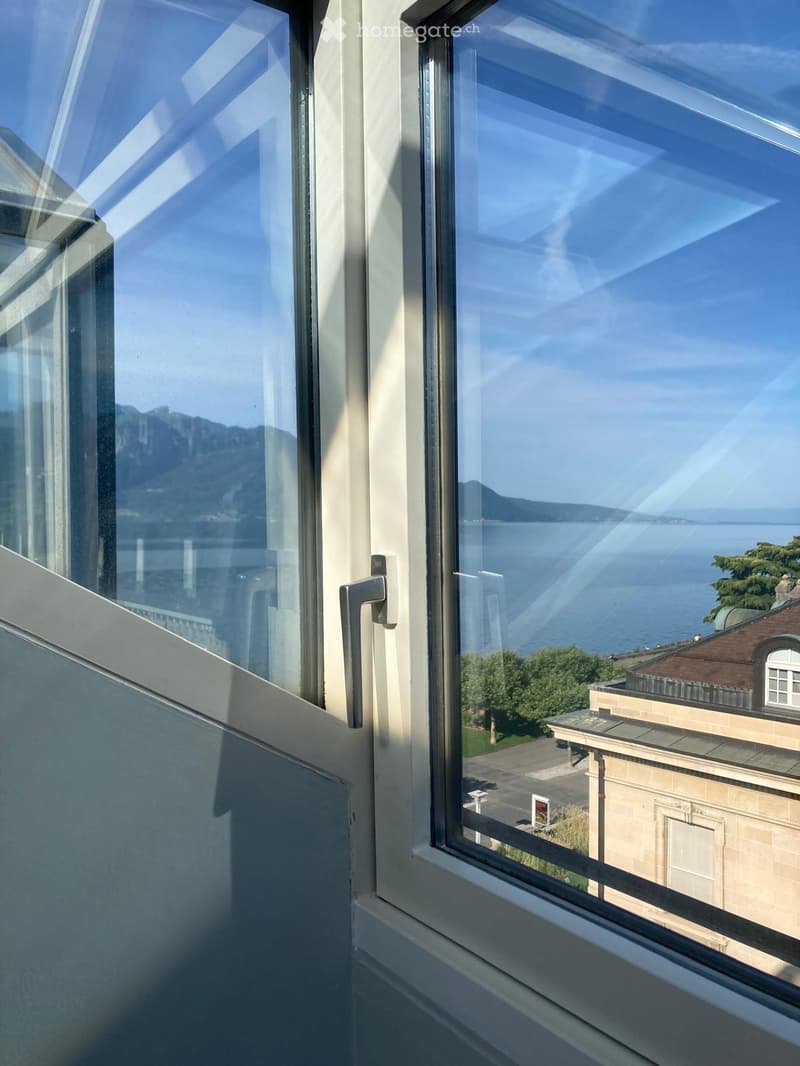 View from a balcony showing a scenic lake and distant mountains.