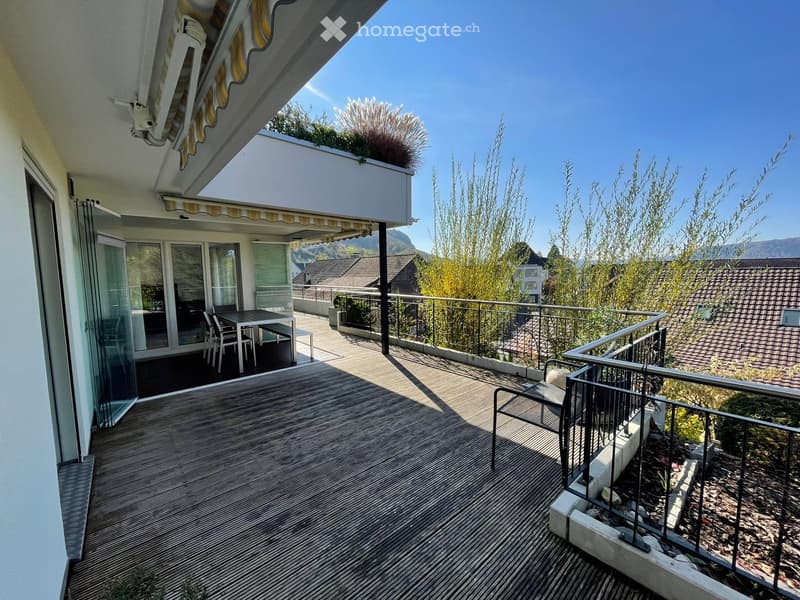 wooden deck, glass doors, table and chairs, metal railings, plants, scenic mountain view