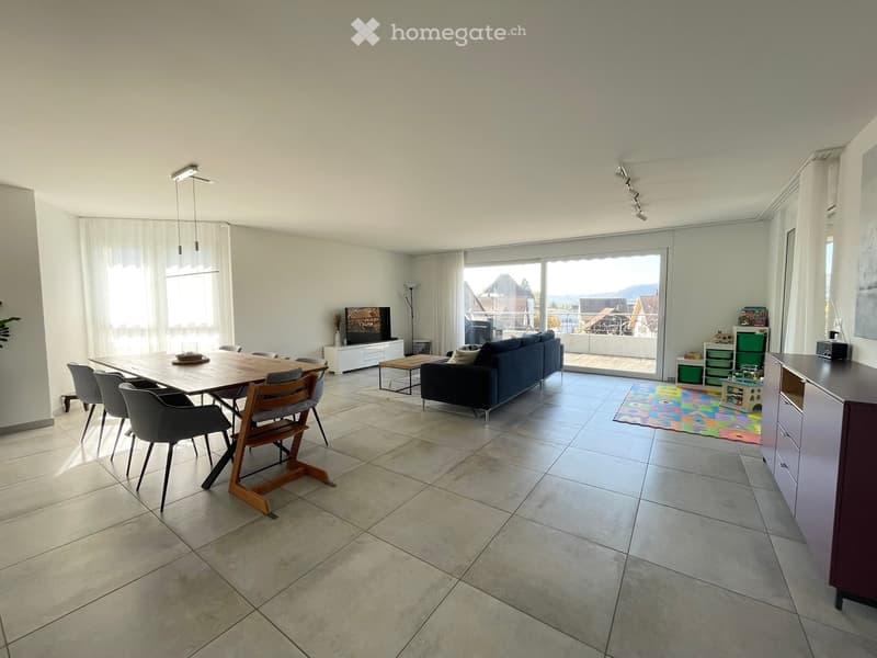 large open space with dining area and living area, large balcony, wooden table, chairs, couch, TV
