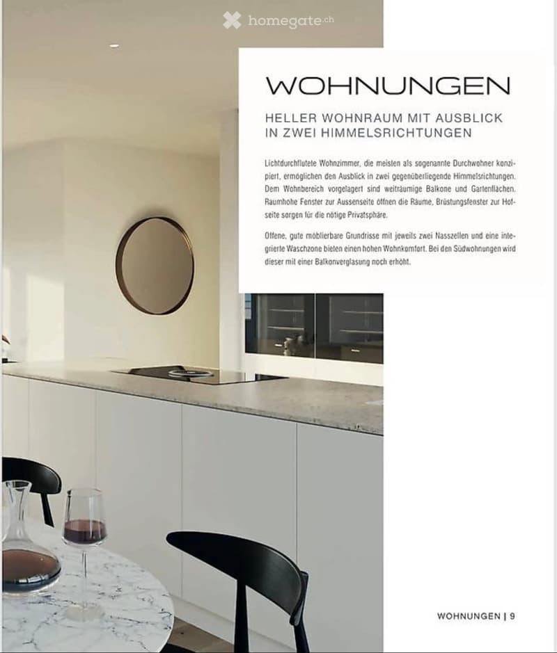 Modern kitchen area with white cabinets, a marble countertop, and a small dining setup with a table, chairs, wine glass, and decanter.