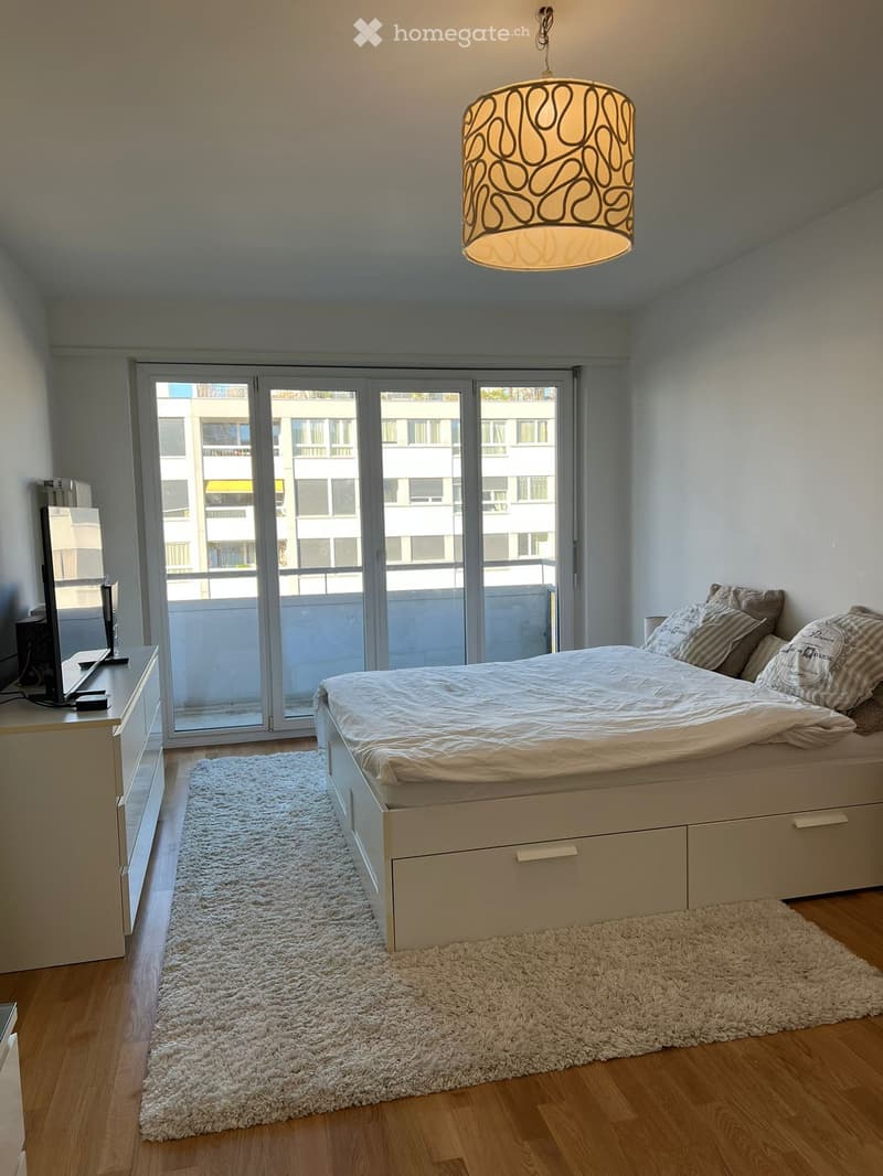 Bedroom with bed, TV, cabinet, carpet, balcony, sliding glass doors