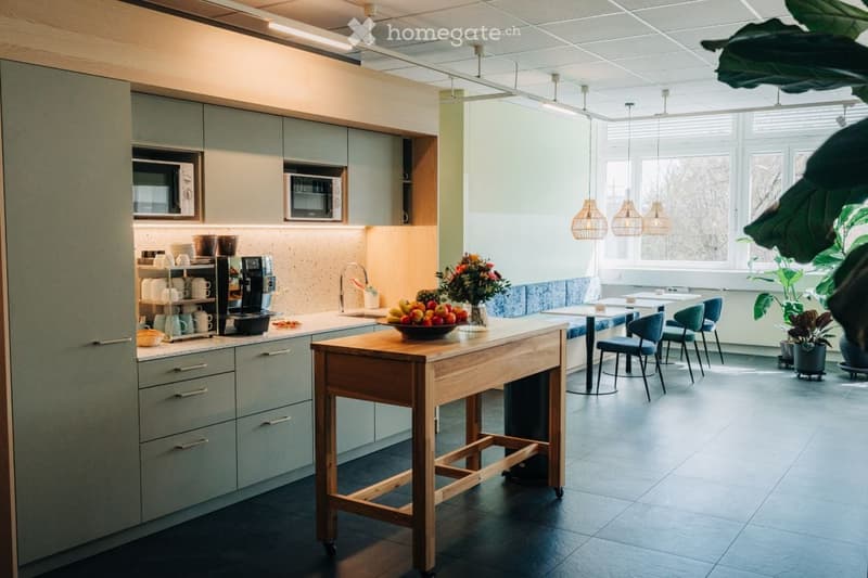 Kitchen. Modern kitchen with grey cabinets, a wooden island, pendant lights, and a dining area with chairs and a table.