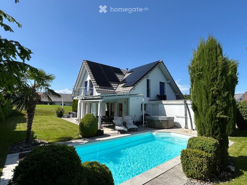 Modern house with solar panels, swimming pool, and a covered terrace with outdoor seating.