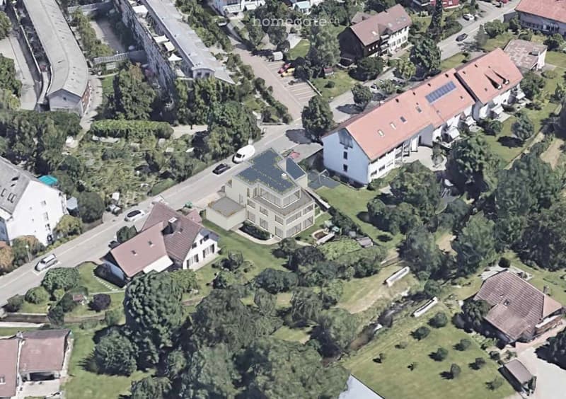Building. Aerial view of a residential area with multiple houses, solar panels on rooftops, and surrounding greenery.