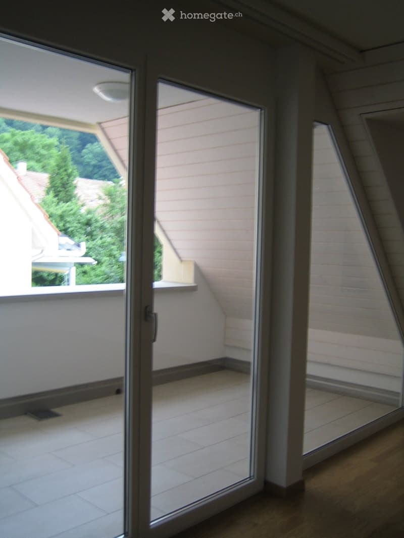 sliding glass doors, balcony, white tiled floor, white walls, ceiling light, view of trees