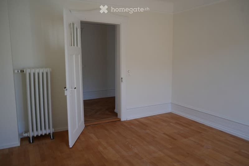 empty room, wooden floor, white walls, open door, radiator