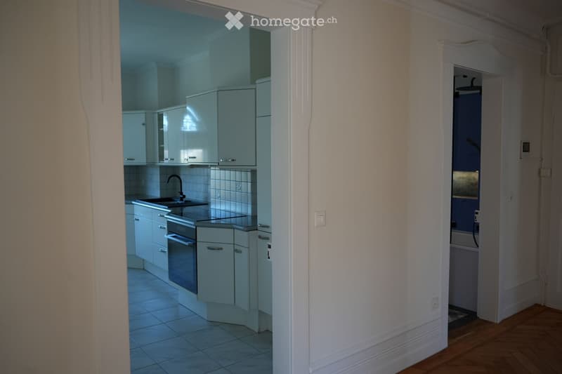 modern kitchen with white cabinets, tiled floor, sink, oven, and a window