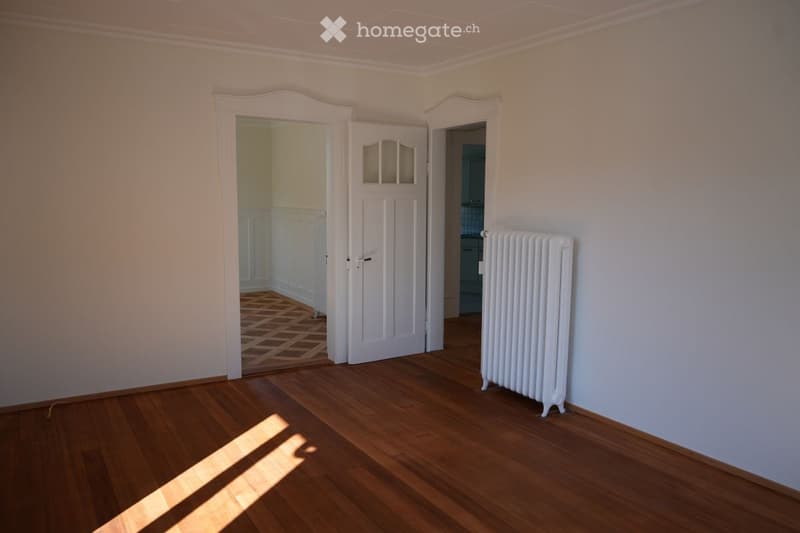 empty room, wooden floor, white walls, white radiator, two doors