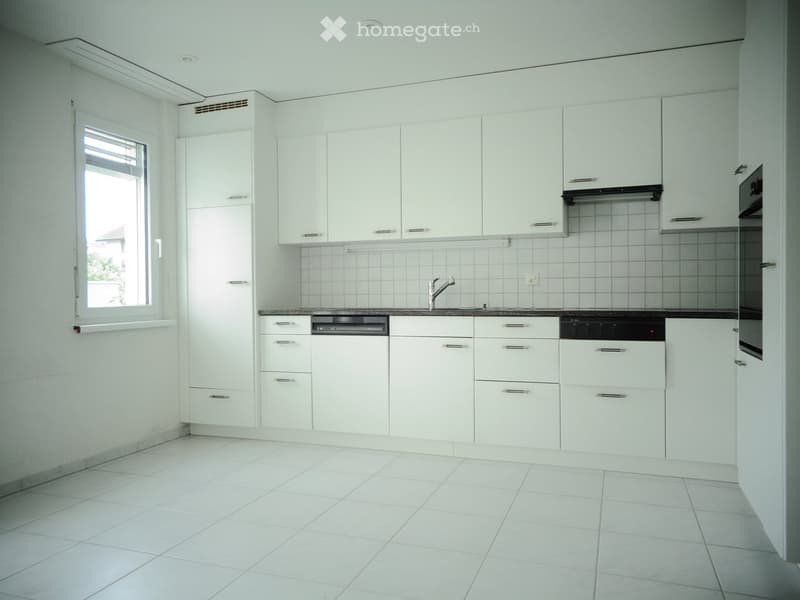Modern kitchen with white cabinets, tiled backsplash, and white tiled flooring. Features a sink with a modern faucet and a built-in dishwasher.