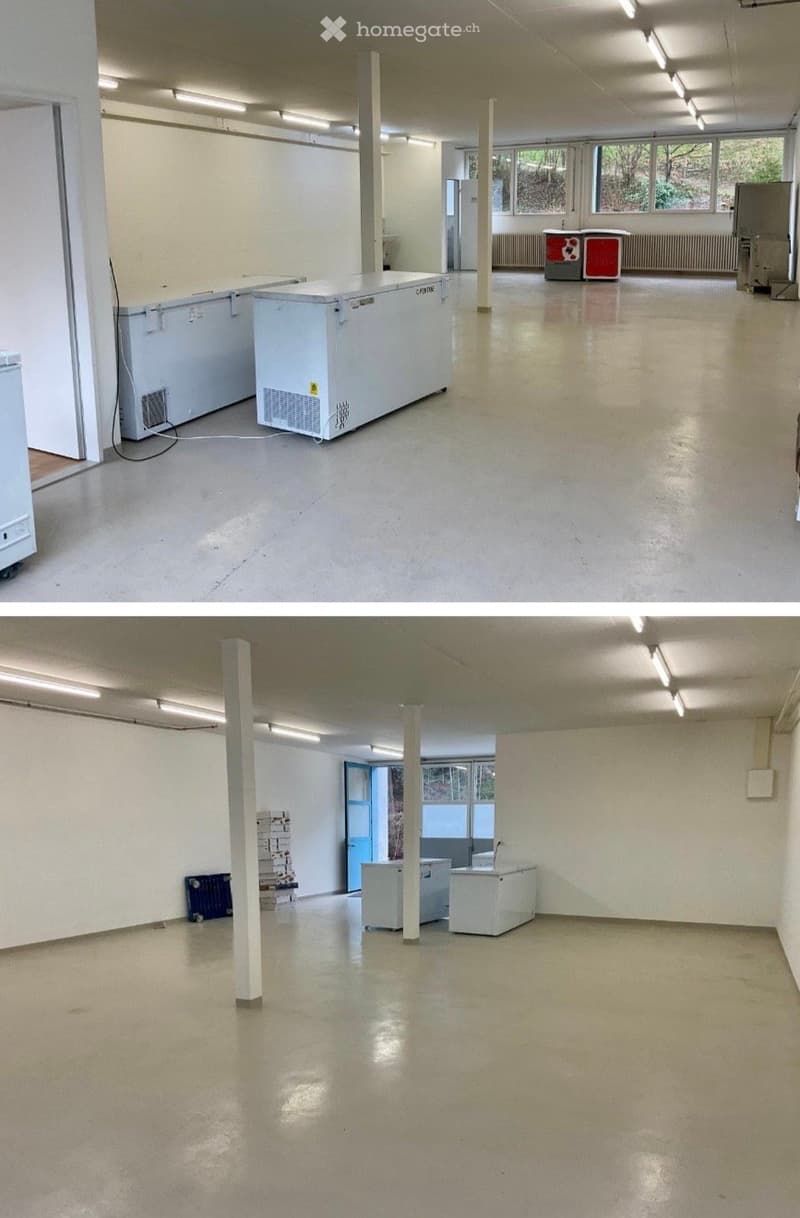 Empty room with white walls, polished concrete floor, fluorescent lighting, and industrial-style columns. Minimal furnishings include a few large white storage units and a small blue crate.