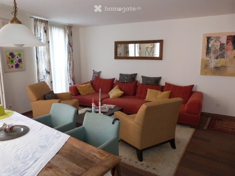 long red sofa, two side tables, carpet, three armchairs, a large dining table, mirror, artwork, window with curtains