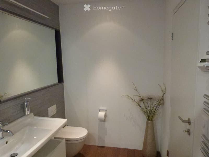 bathroom with white sink, mirror, toilet, flowers in vase, radiator, white tiles, wooden floor