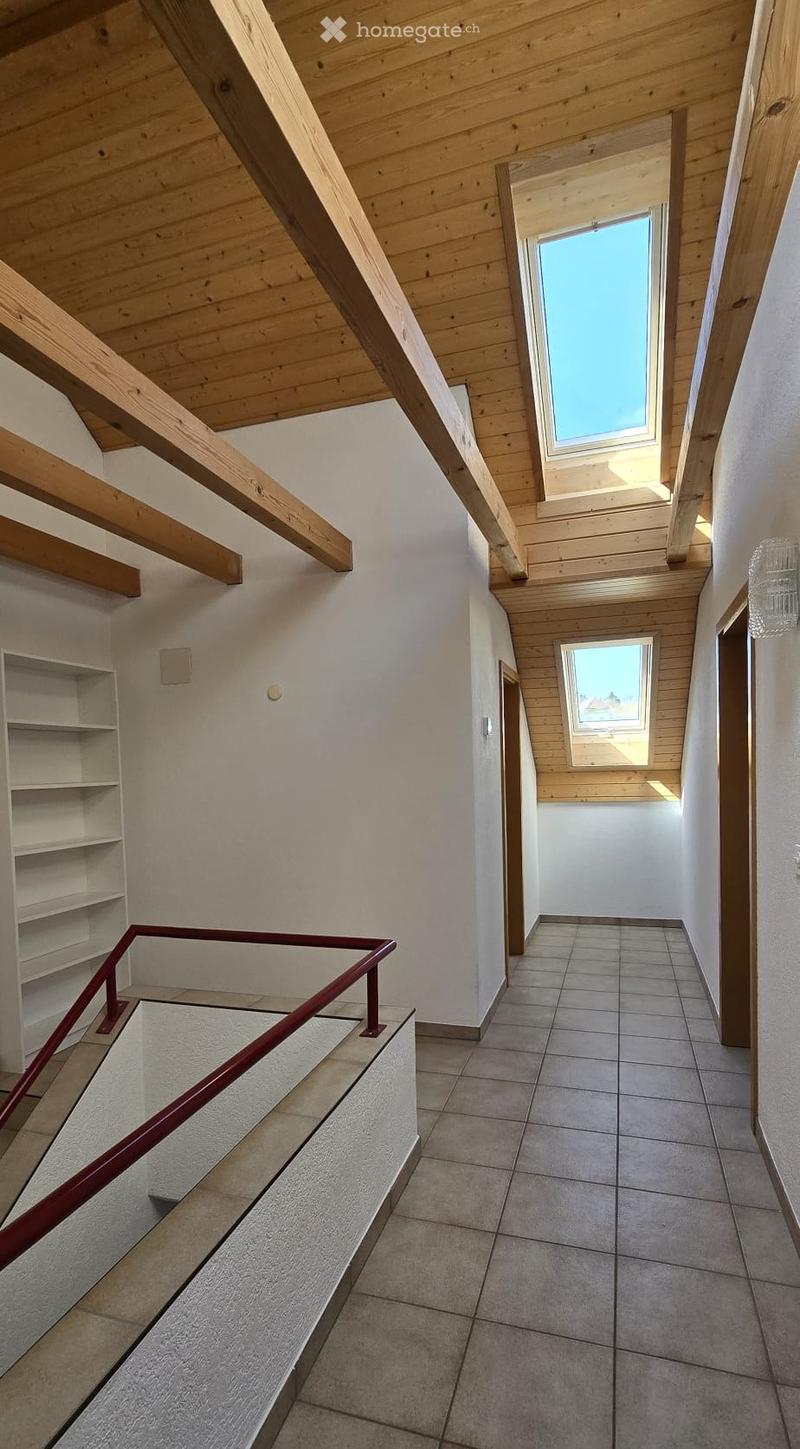 empty room, wooden ceiling, tiled floor, white walls, two skylights, white shelf, red handrail