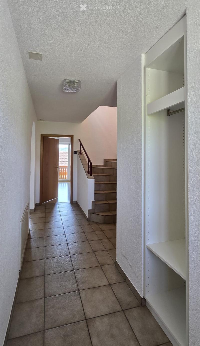 tiled floor, white walls, wooden door, staircase, radiator, wardrobe