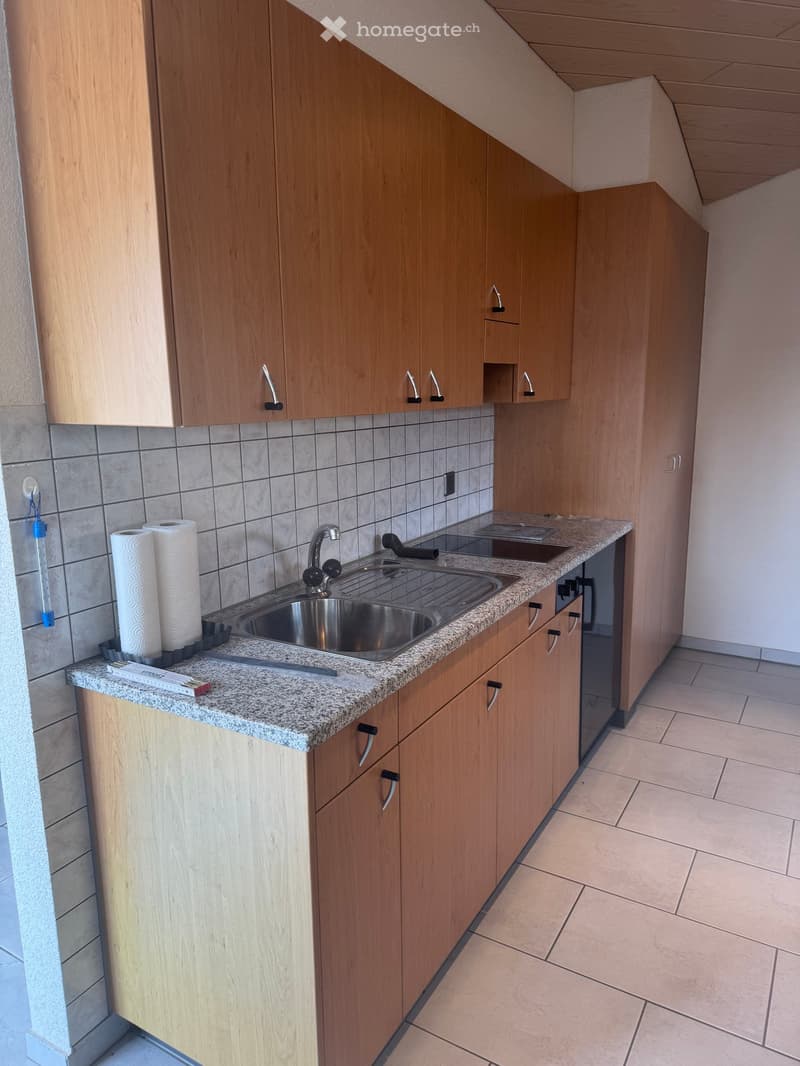 modern kitchen with wooden cabinets, granite countertop, stainless steel sink, dishwasher, and washing machine