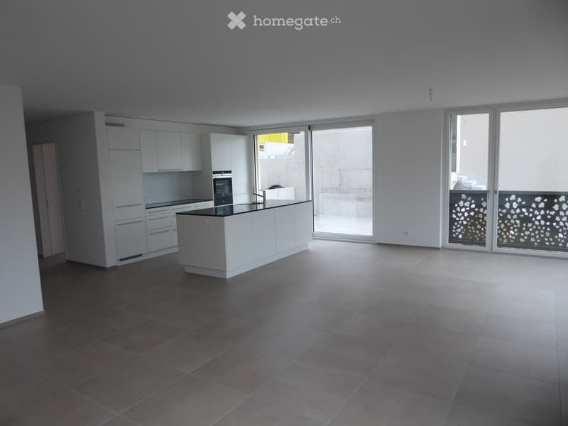 Kitchen. Modern kitchen with white cabinets, a central island, and large windows leading to a balcony.