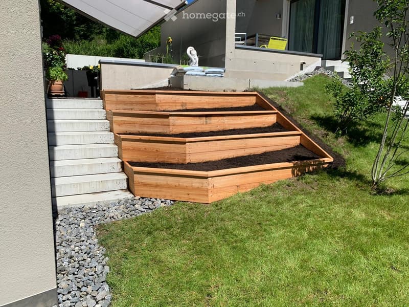 Garden / Outdoor Area. Garden with wooden raised beds, concrete steps, and a small grassy area.