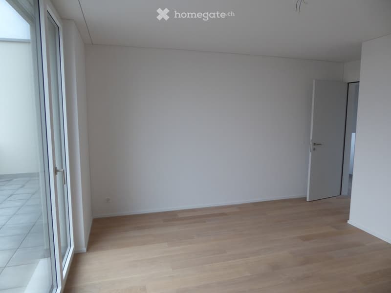 Unfurnished Room. Empty room with light wooden flooring, white walls, and a large glass door leading to a tiled area.