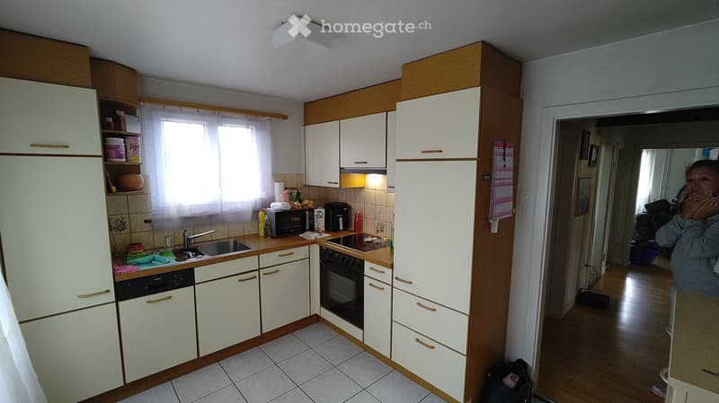 Kitchen. Modern kitchen with white cabinets, stainless steel appliances, and a window with blinds. Includes a refrigerator, oven, microwave, sink, and dishwasher.