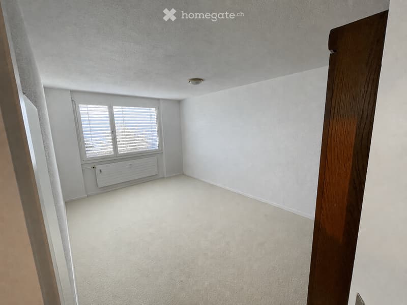 Empty room with white walls, carpeted floor, and a window with blinds. No furniture or equipment is present.