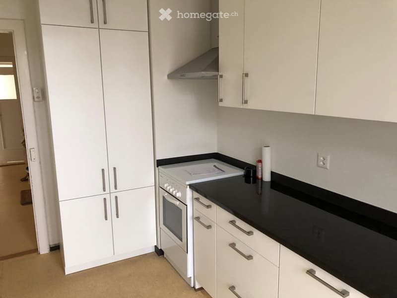 kitchen with black countertops, white cabinets, gas stove, white appliances
