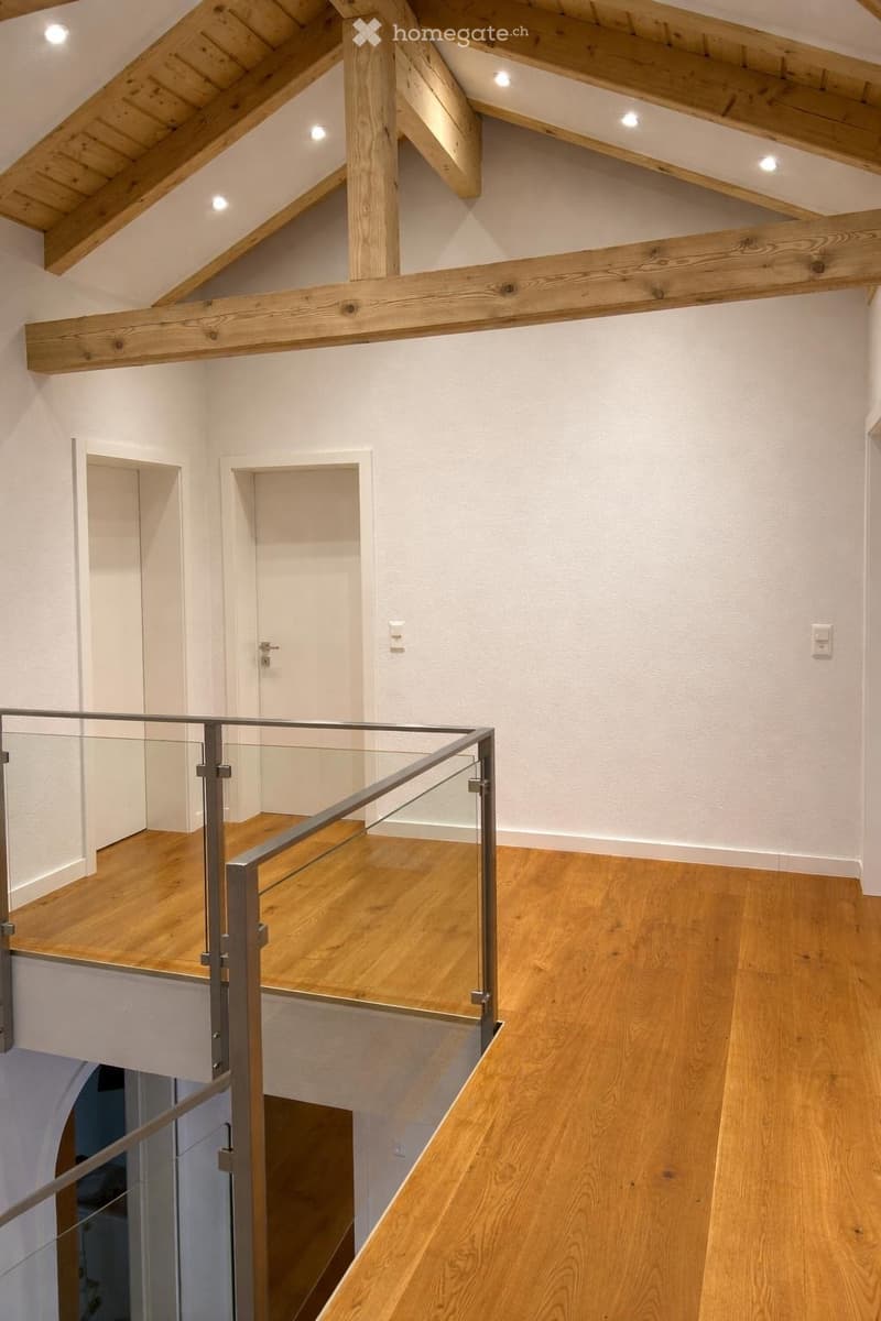 wooden ceiling, wooden floor, glass railing, two doors, white walls