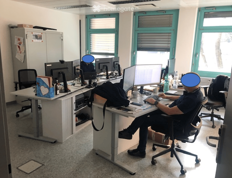 Office space with desks, multiple computer monitors, office chairs, and various office supplies.