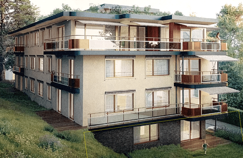 Modern multi-story building with balconies, large windows, and a raised ground floor. The structure features a flat roof and contemporary design.
