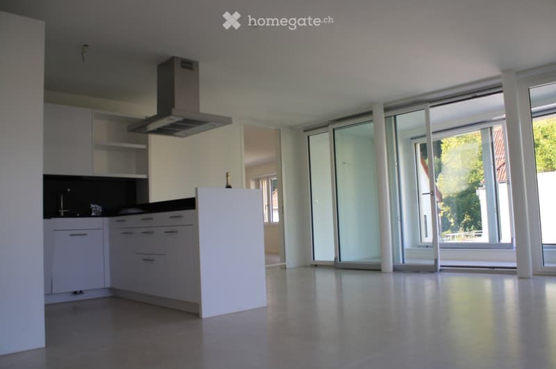 white cabinetry, tile floor, center island, stainless steel range hood, large sliding doors, balcony