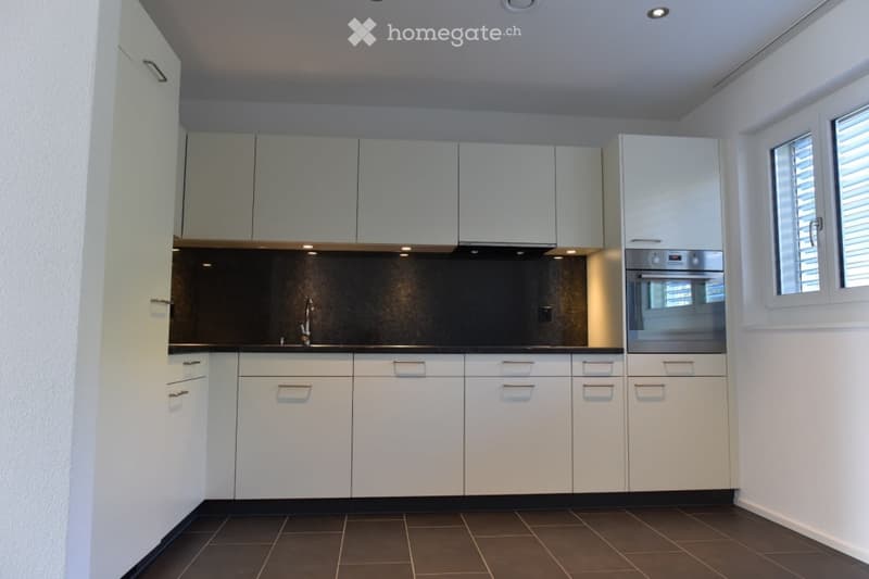 modern kitchen with white cabinets, tiled floor, stainless steel appliances, large sink with faucet