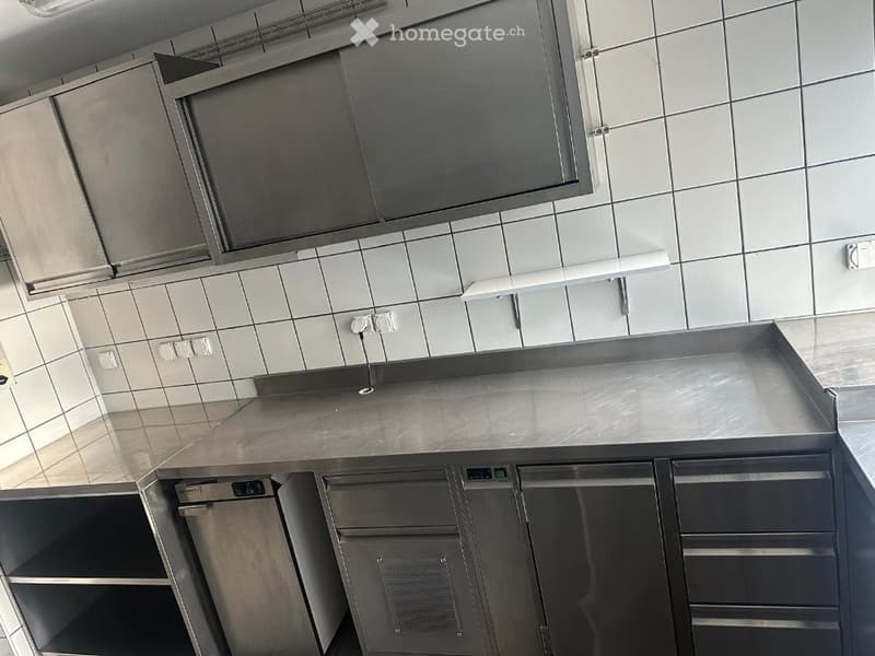 Modern stainless steel kitchen with built-in dishwasher, cabinets, and countertop.
