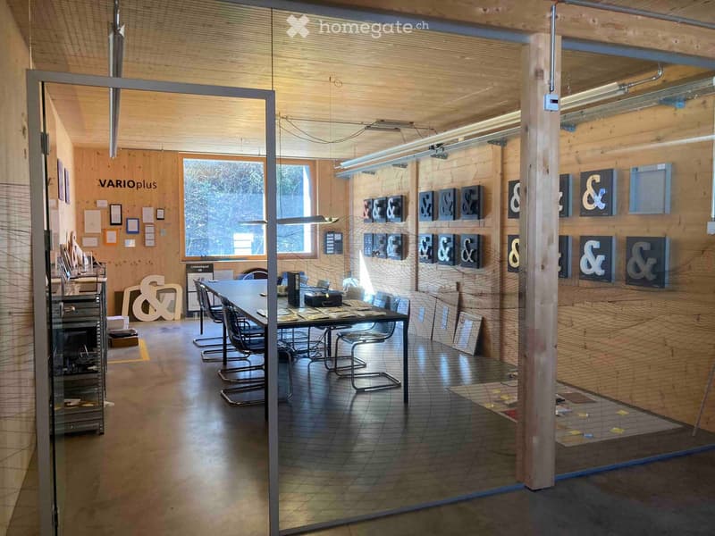 modern office room with wooden walls, glass partition, long table, chairs, lamps, artwork on the wall, window