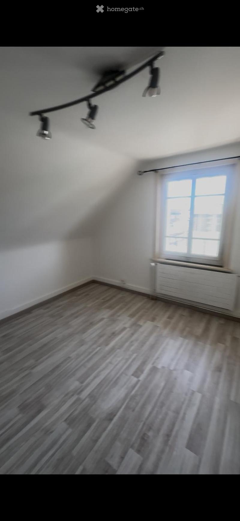 Empty room with wooden flooring, white walls, and a window with blinds. No furniture or equipment is present.