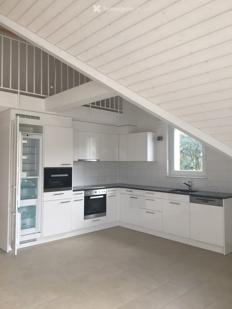 Modern kitchen with white cabinets, stainless steel appliances, and a black countertop. Features include a refrigerator, oven, dishwasher, and sink.