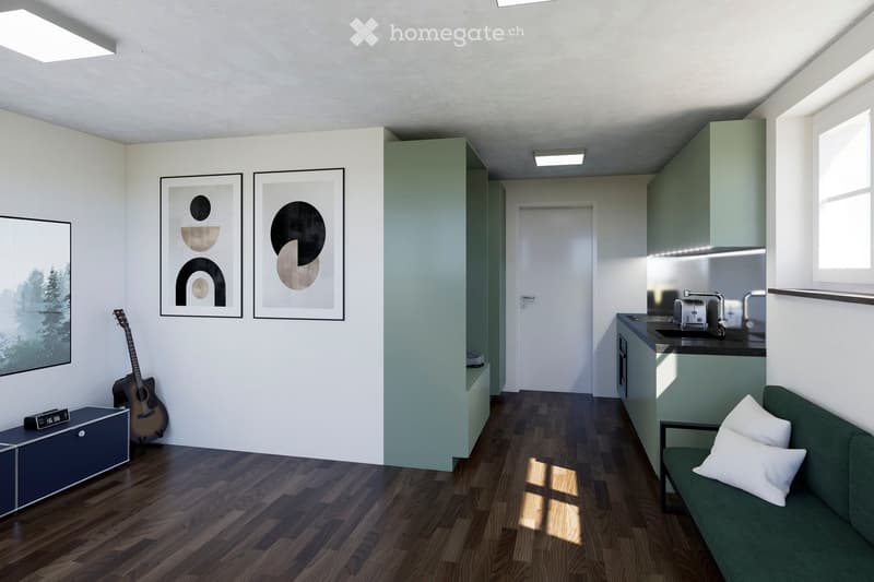 Modern open-plan living and kitchen area with wooden flooring, white walls, and large windows. Features a green sofa, a guitar, framed artwork, a kitchen counter with a toaster, and built-in cabinets.