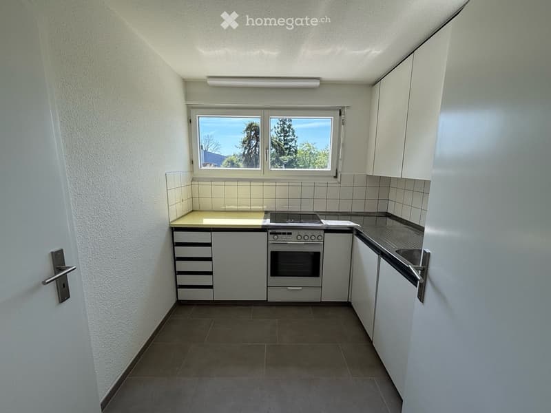 Modern small kitchen with oven, sink, tiled flooring, a window, white walls and cabinets
